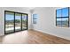 Bright bedroom featuring hardwood floors, two windows, and access to a private balcony at 5032 W Longfellow Ave, Tampa, FL 33629