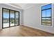 Bright, spacious bedroom featuring hardwood floors and scenic views from large windows and glass doors at 5032 W Longfellow Ave, Tampa, FL 33629