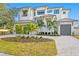 Stunning two-story home featuring lush landscaping, a circular driveway, and a three-car garage at 5032 W Longfellow Ave, Tampa, FL 33629