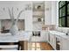 Kitchen with white cabinets, chevron backsplash, floating shelves, stainless steel appliances, and modern decor at 5032 W Longfellow Ave, Tampa, FL 33629