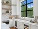 Bright kitchen with a farmhouse sink, open shelving, and a large window at 5032 W Longfellow Ave, Tampa, FL 33629