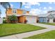 Two-story house with orange exterior and paved driveway at 6409 Oyster Island Cv, Apollo Beach, FL 33572