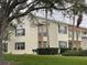 Two-story condo building with green lawn and trees at 201 Silver Lake Dr # 101, Venice, FL 34292