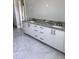 Modern bathroom vanity with gray marble countertop and sleek black hardware, complemented by light gray flooring at 3109 W Knights Ave, Tampa, FL 33611