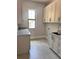 Laundry room with granite counter tops, utility sink and custom cabinetry at 3109 W Knights Ave, Tampa, FL 33611