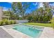 Inviting pool and spa with travertine surround and landscaped backyard at 3109 W Knights Ave, Tampa, FL 33611