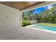 Back porch leading to a pool surrounded by lush greenery and a privacy fence at 3109 W Knights Ave, Tampa, FL 33611