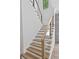 Stylish staircase featuring light wood treads, white risers, and a modern glass railing system at 3109 W Knights Ave, Tampa, FL 33611