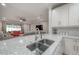 Kitchen island with double sink and granite countertop overlooking living room at 903 Heritage Groves Dr, Brandon, FL 33510