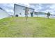 View of the two-story home's green backyard with white fence at 11946 Brighton Knoll Loop, Riverview, FL 33579