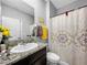 Bathroom with granite vanity, modern fixtures, bright lighting, and patterned shower curtain at 11946 Brighton Knoll Loop, Riverview, FL 33579