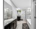 Modern bathroom with granite counters, dual sinks, soaking tub, glass shower, and tile floors at 11946 Brighton Knoll Loop, Riverview, FL 33579