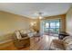 Living room with hardwood floors, a ceiling fan, and access to a patio at 2400 Winding Creek Blvd # 3-202, Clearwater, FL 33761