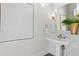 Modern powder room with white pedestal sink and herringbone tile at 96 Martinique Ave, Tampa, FL 33606