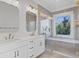 Bathroom with double vanity, walk-in shower, and soaking tub at 96 Martinique Ave, Tampa, FL 33606