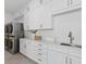 Bright laundry room with white cabinets and a utility sink at 96 Martinique Ave, Tampa, FL 33606
