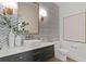 Stylish powder room with chevron tile, modern vanity, and elegant fixtures at 96 Martinique Ave, Tampa, FL 33606