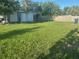 Backyard with lush green grass, fence, and an outdoor storage building at 1006 39Th W Ave, Bradenton, FL 34205