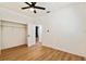 Bedroom with wood-look flooring, ceiling fan, and spacious closet at 3810 N Arlington Ave, Tampa, FL 33603