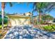 House exterior featuring a light yellow exterior, stone accents, and a two-car garage at 422 Down Pine Dr, Seffner, FL 33584