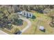 Aerial of a charming home with a long driveway, mature trees, and manicured lawn, surrounded by lush greenery at 8529 Kenton Rd, Wesley Chapel, FL 33545