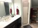 Modern bathroom with dark cabinets, a white countertop, a framed mirror and a glass-enclosed shower at 8529 Kenton Rd, Wesley Chapel, FL 33545