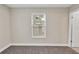 Simple bedroom with a window, carpet, and access to hallway at 3721 Wiggins Leaf St, Tampa, FL 33619