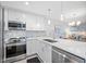 Modern white kitchen with stainless steel appliances and quartz countertops at 8251 Brent St # 912, Port Richey, FL 34668