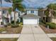 Two-story house with a light blue exterior, a white garage door, and a driveway at 12950 Fennway Ridge Dr, Riverview, FL 33579
