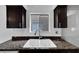 Kitchen sink and granite countertop with dark brown cabinets at 12950 Fennway Ridge Dr, Riverview, FL 33579