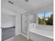Modern bathroom with a tub, shower, and view to backyard at 12950 Fennway Ridge Dr, Riverview, FL 33579