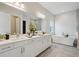 Bathroom featuring a dual vanity, soaking tub, and modern finishes at 17721 Roost Pl, Lakewood Ranch, FL 34211