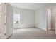 Bright bedroom featuring neutral carpeting, a window and an open doorway at 17721 Roost Pl, Lakewood Ranch, FL 34211