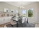 Dining room with large windows, elegant decor, and a stylish chandelier, creating a perfect setting for entertaining at 17721 Roost Pl, Lakewood Ranch, FL 34211