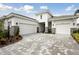 Elegant home showcasing a three-car garage, paved driveway, and beautifully landscaped front yard at 17721 Roost Pl, Lakewood Ranch, FL 34211
