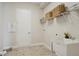 Functional laundry room with utility sink, shelving, and ample space for appliances at 17721 Roost Pl, Lakewood Ranch, FL 34211