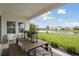 Covered patio with stylish dining set overlooking a serene lake at 17721 Roost Pl, Lakewood Ranch, FL 34211
