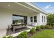 Covered patio with stylish dining set and comfortable chairs overlooking the manicured lawn at 17721 Roost Pl, Lakewood Ranch, FL 34211