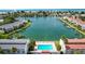 Aerial view of a waterfront community showcasing a pool, canal access, and nearby beach at 12246 2Nd E St # 503, Treasure Island, FL 33706