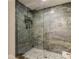 Modern bathroom featuring a glass-enclosed shower with designer stone tile and mosaic tile flooring at 12246 2Nd E St # 503, Treasure Island, FL 33706