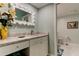 Stylish bathroom vanity with marble countertop, white cabinetry, and decorative mirror above at 12246 2Nd E St # 503, Treasure Island, FL 33706