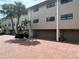 Exterior shot of townhomes with private garages and a red brick driveway framed by lush landscaping at 12246 2Nd E St # 503, Treasure Island, FL 33706
