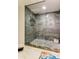 Modern walk-in shower with marble-look tile, a rainfall showerhead, and mosaic tile flooring at 12246 2Nd E St # 503, Treasure Island, FL 33706