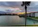 Beautiful waterfront view with a palm tree, condos, and boat docks in the background at sunset at 12246 2Nd E St # 503, Treasure Island, FL 33706