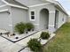 Landscaped entryway of a light gray house with an arched entry at 7855 Davie Ray Dr, Zephyrhills, FL 33540