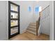 Inviting entryway with natural light, modern door, and hardwood stairs with contrasting railing at 2355 Bahia Vista St, Sarasota, FL 34239