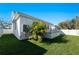 Exterior shot of the home from the backyard, featuring lush tropical landscaping and a modern back patio at 2355 Bahia Vista St, Sarasota, FL 34239