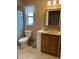 Bathroom features a toilet, sink vanity with wood cabinets, and a shower at 10911 Hachita Dr, Port Richey, FL 34668