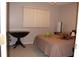 Bedroom with a double bed, dark wood table, and plush toys at 10911 Hachita Dr, Port Richey, FL 34668