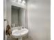 Small, updated powder room with pedestal sink and mirror at 31396 Cabana Rye Ave, San Antonio, FL 33576
